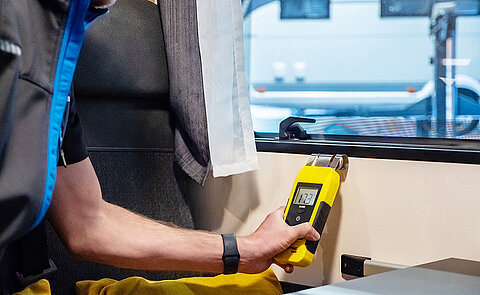 Werkstatt-Mitarbeiter von Caravaning Center Schmidtmeier bei der Durchführung eines Dichtigkeitstests mit einem Messgerät.