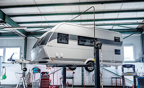 Hobby Wohnwagen auf einer Hebebühne in der Werkstatt von Caravaning Center Schmidtmeier.